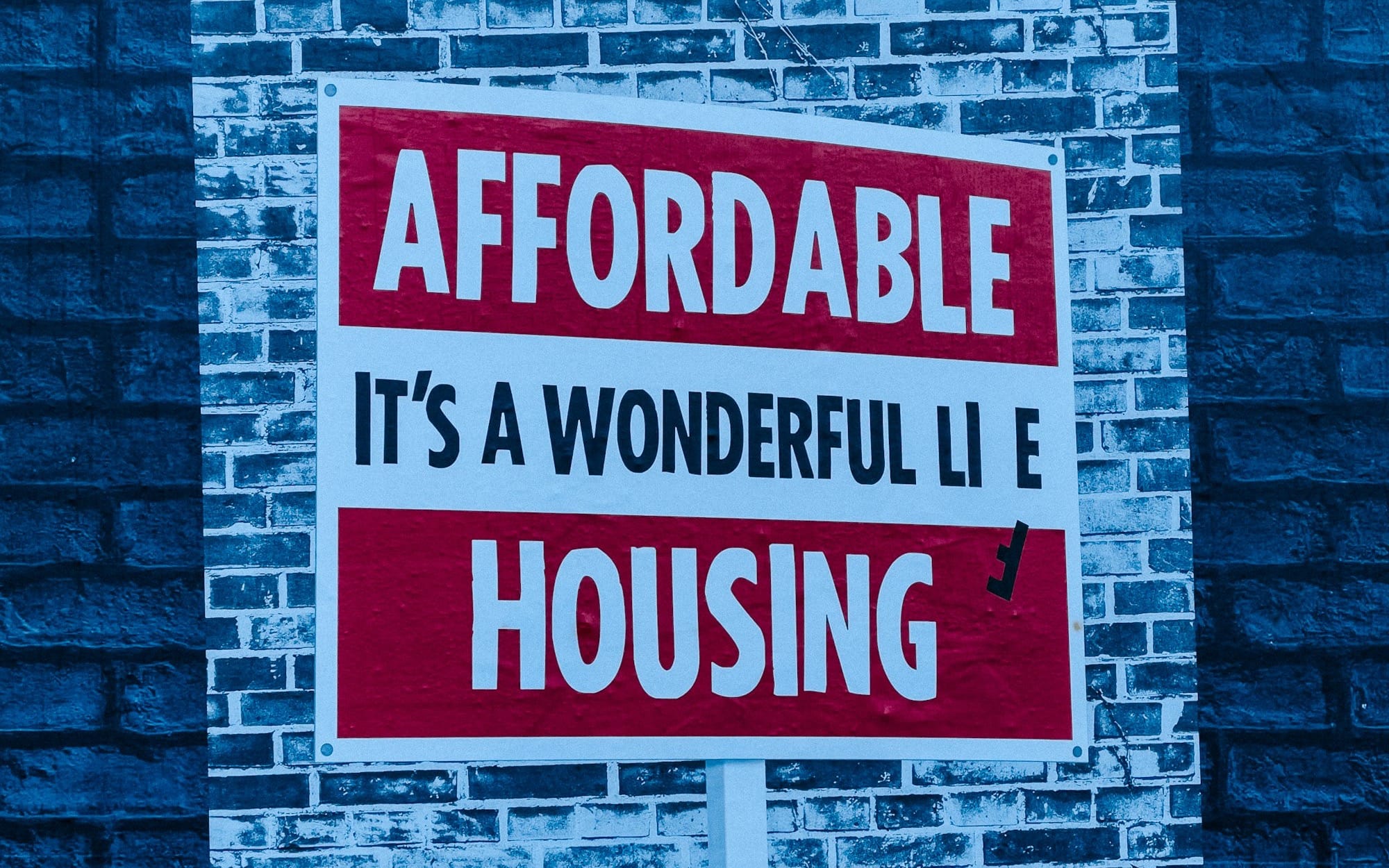 a red and white sign on a brick wall